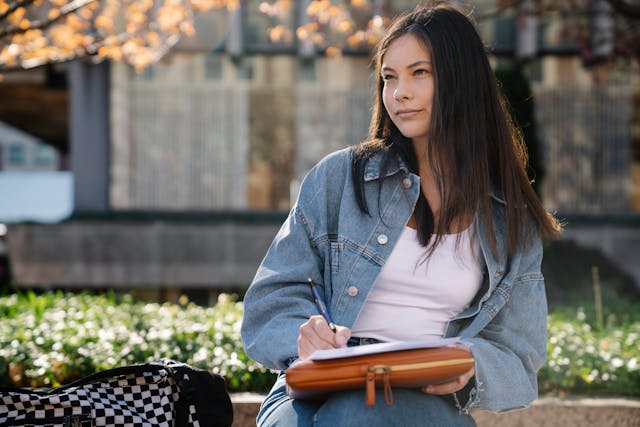 Student writing in a notebook outdoors in Florence