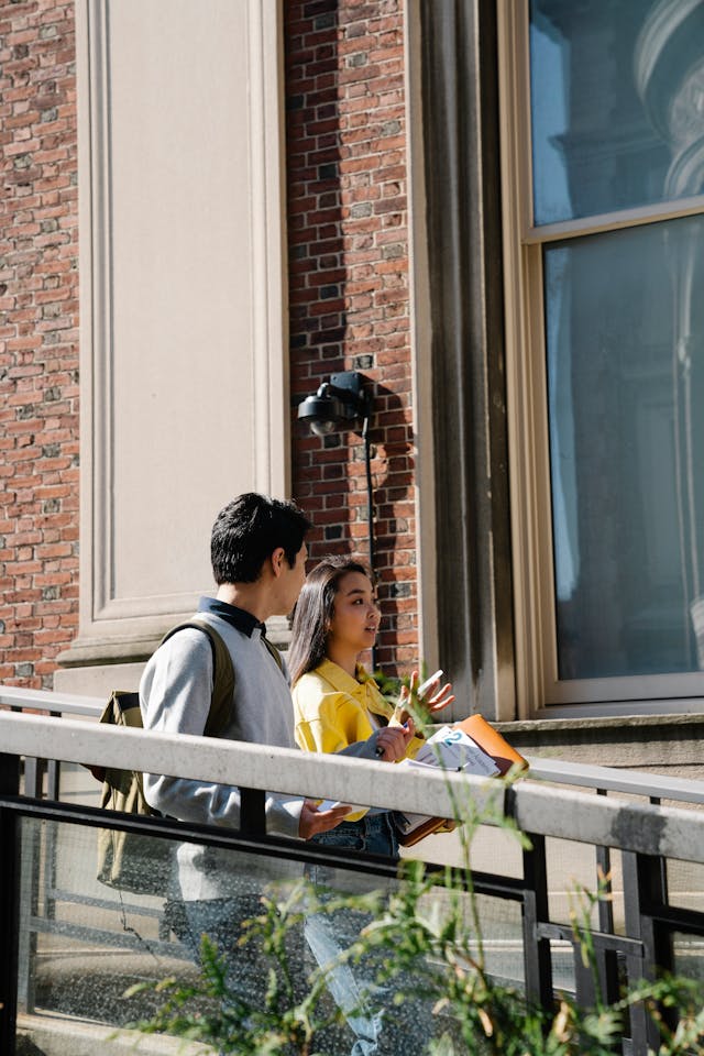 Two NECA students walking and talking on campus