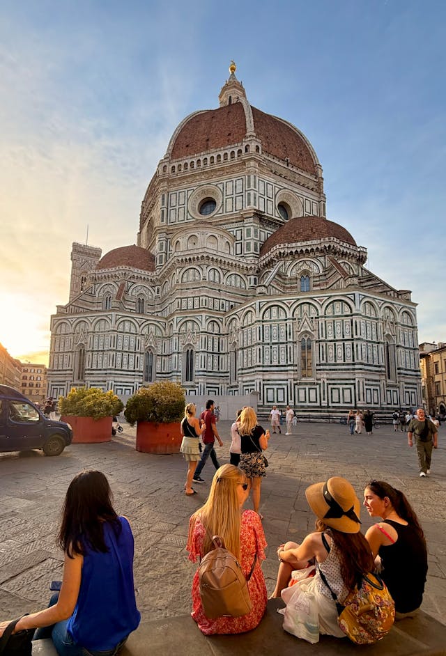 Students sitting in front of the Florence Duomo at sunset